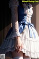 A woman in a blue and white dress is posing for a picture.