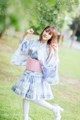 A woman in a blue and white kimono is posing for a picture.