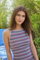 A young woman in a striped tank top posing for a picture.